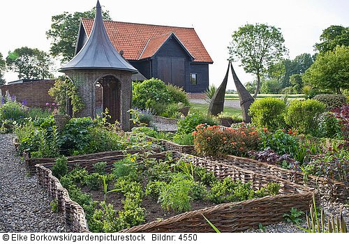 Cottagegarten mit weidegefassten Beeten und Weidenpavillon