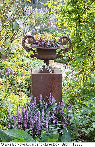 Säule und Vase im Garten  Liriope muscari  Heuchera