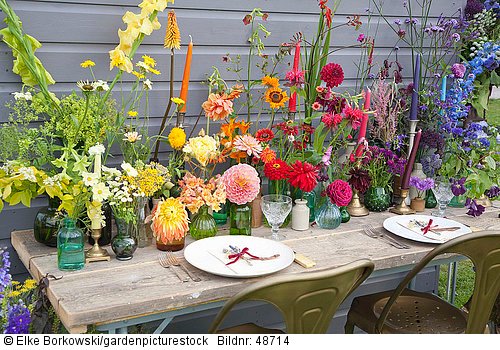 Tischdekoration mit Blüten in Regenbogenfarben